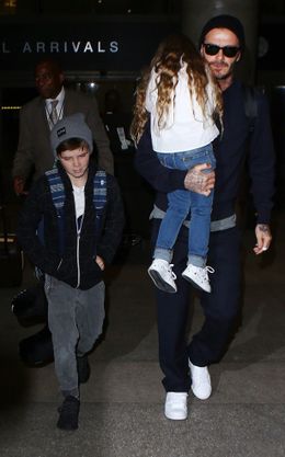 娘のハーパーを抱いて歩くデビッド・ベッカム