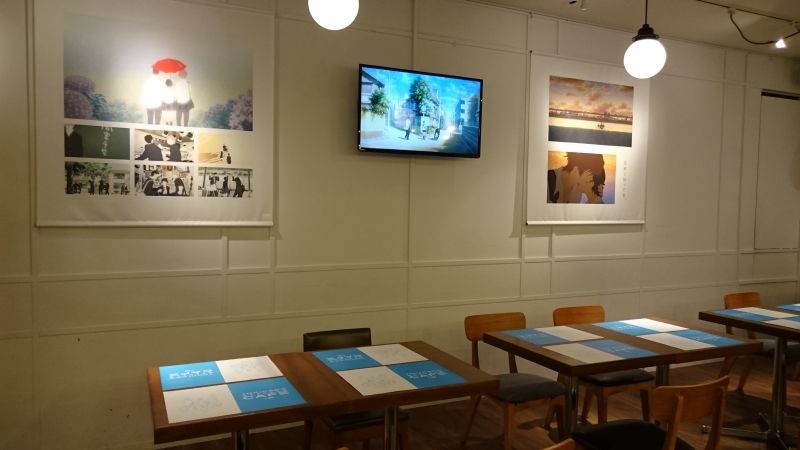 カフェの席には場面カットや、モニターによる展示も行われている